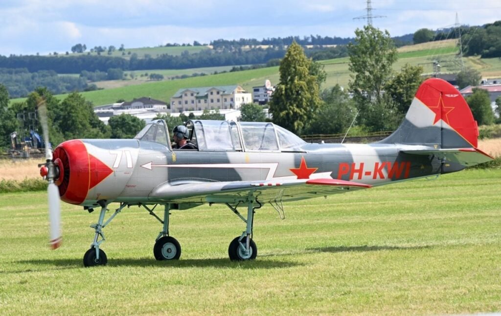 Un avion YAK-52 cu o elice este pregătit să decoleze de pe un câmp, iunie 2024