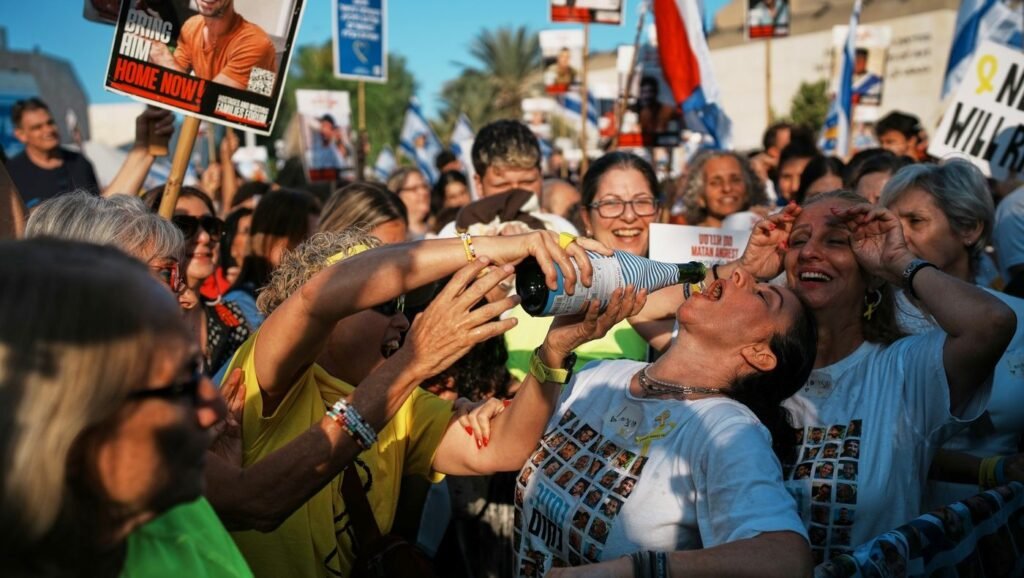 Oamenii se bucură în timp ce se adună pentru a urmări transmisiunea în direct a eliberării ostaticilor israelieni din Gaza, într-o piață cunoscută sub numele de „piața ostaticilor” din Tel Aviv, Israel, luni, 13 octombrie 2025.